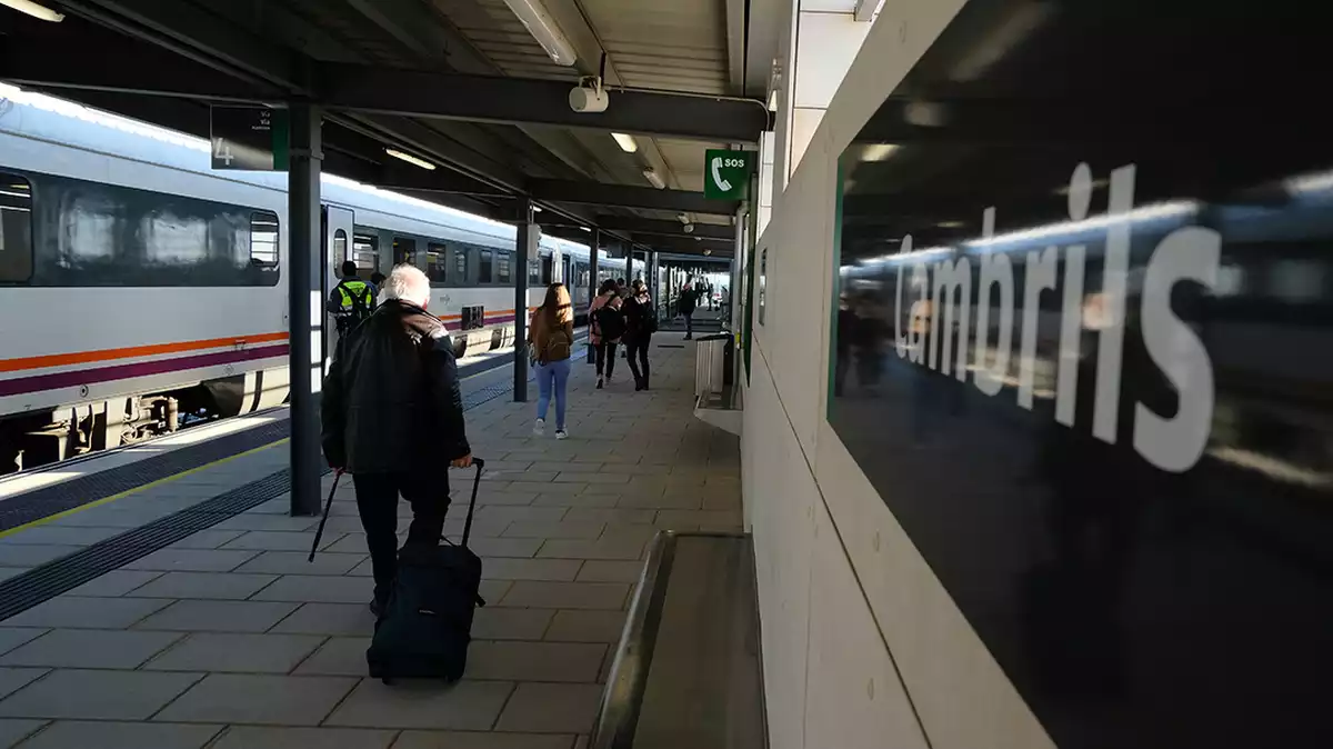 Un usuari del tren camina amb una maleta per una de les andanes de la nova estació de tren de Cambrils.