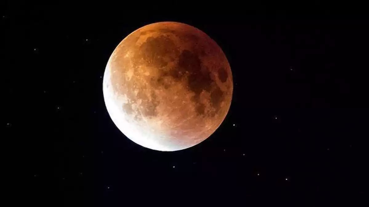 Imatge de la lluna plena amb un color vermellós