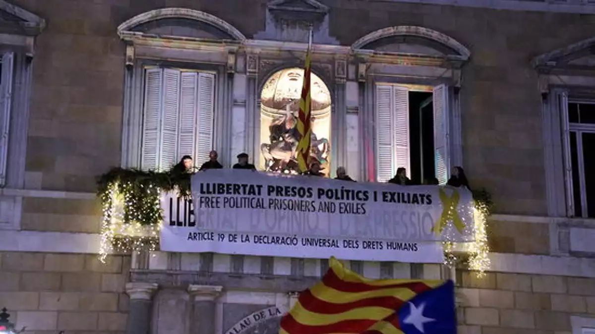 Membres de l'ANC pengen al Palau de la Generalitat la pancarta que ha portat Torra a la inhabilitació, el 3 de gener del 2020