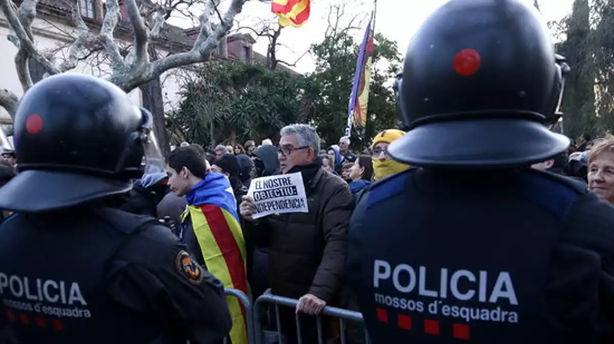 Un grup de manifestants davant de dos agents dels Mossos d'Esquadra al Parlament el 27 de gener de 2020