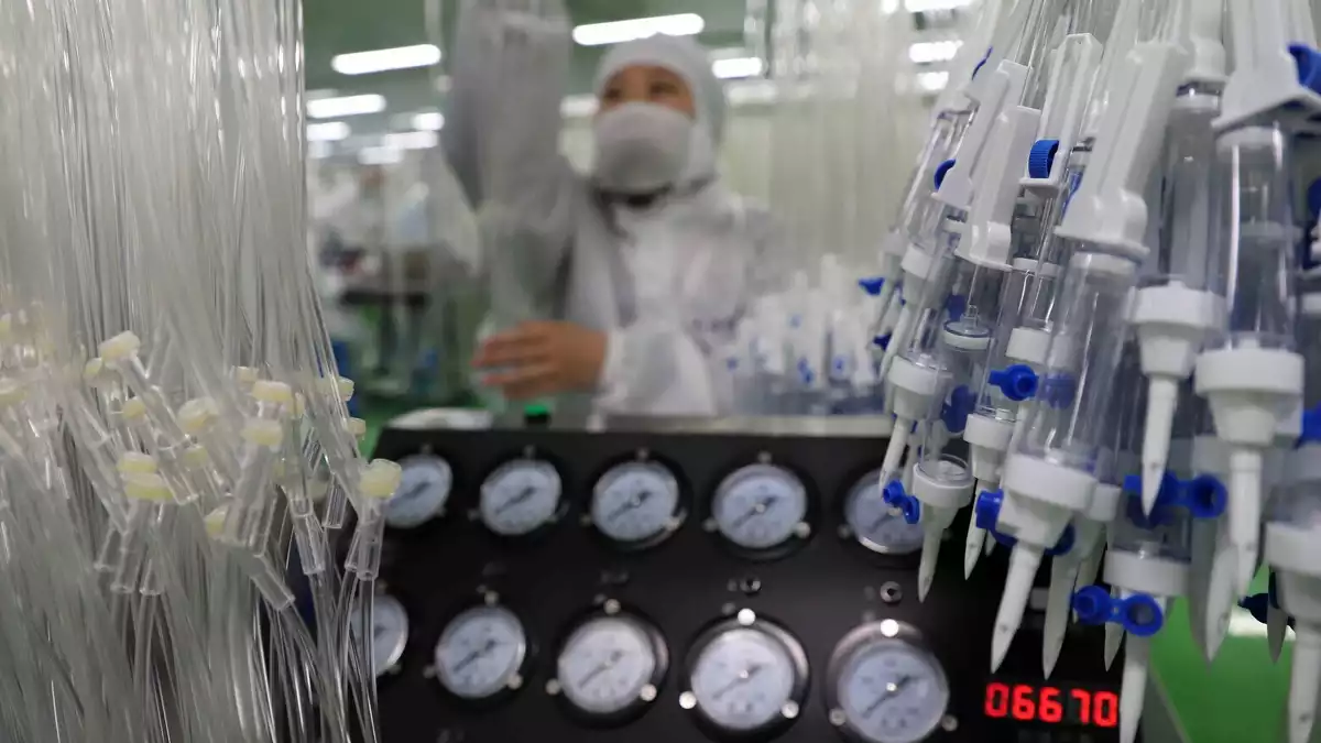 Treballadors en una línia de producció de material mèdic per afrontar el coronavirus el febrer de 2020