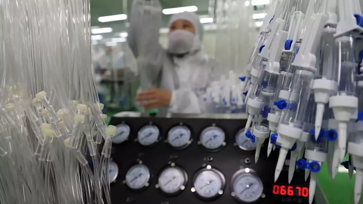 Treballadors en una línia de producció de material mèdic per afrontar el coronavirus el febrer de 2020