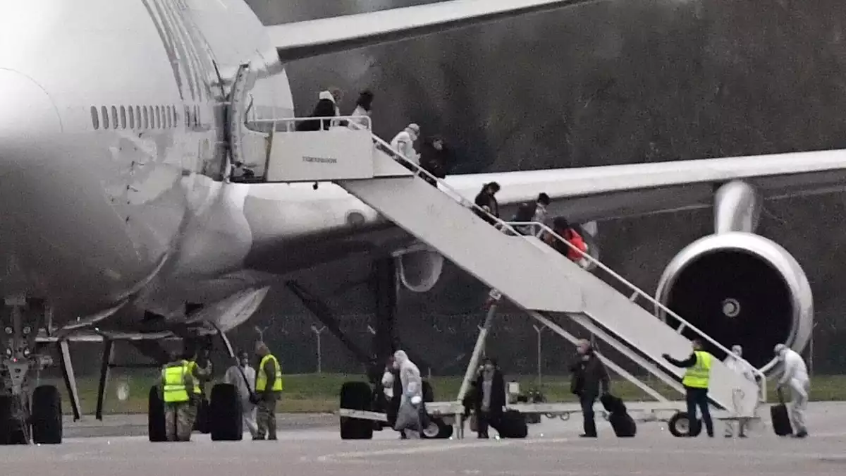 Passatgers britànics repatriats de la Xina abandonant l'avió el 9 de febrer de 2020