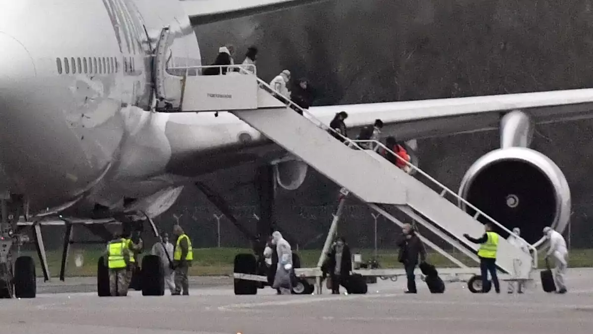 Passatgers britànics repatriats de la Xina abandonant l'avió el 9 de febrer de 2020