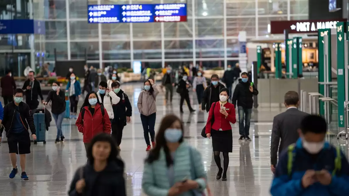 Viatgers i membres d'aerolínies amb màscares durant la crisi del coronavirus, a l'aeroport de Hong Kong