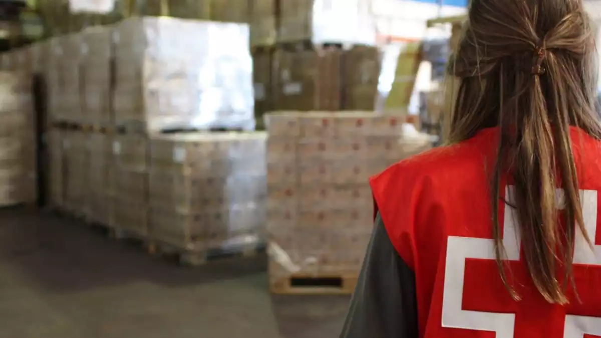 Una voluntària de la Creu Roja, davant el magatzem d'aliments