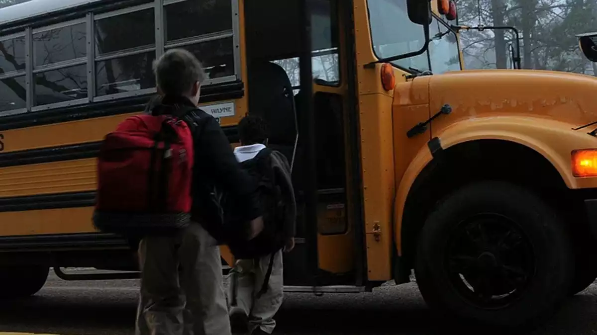Nens pujant a un autobús escolar