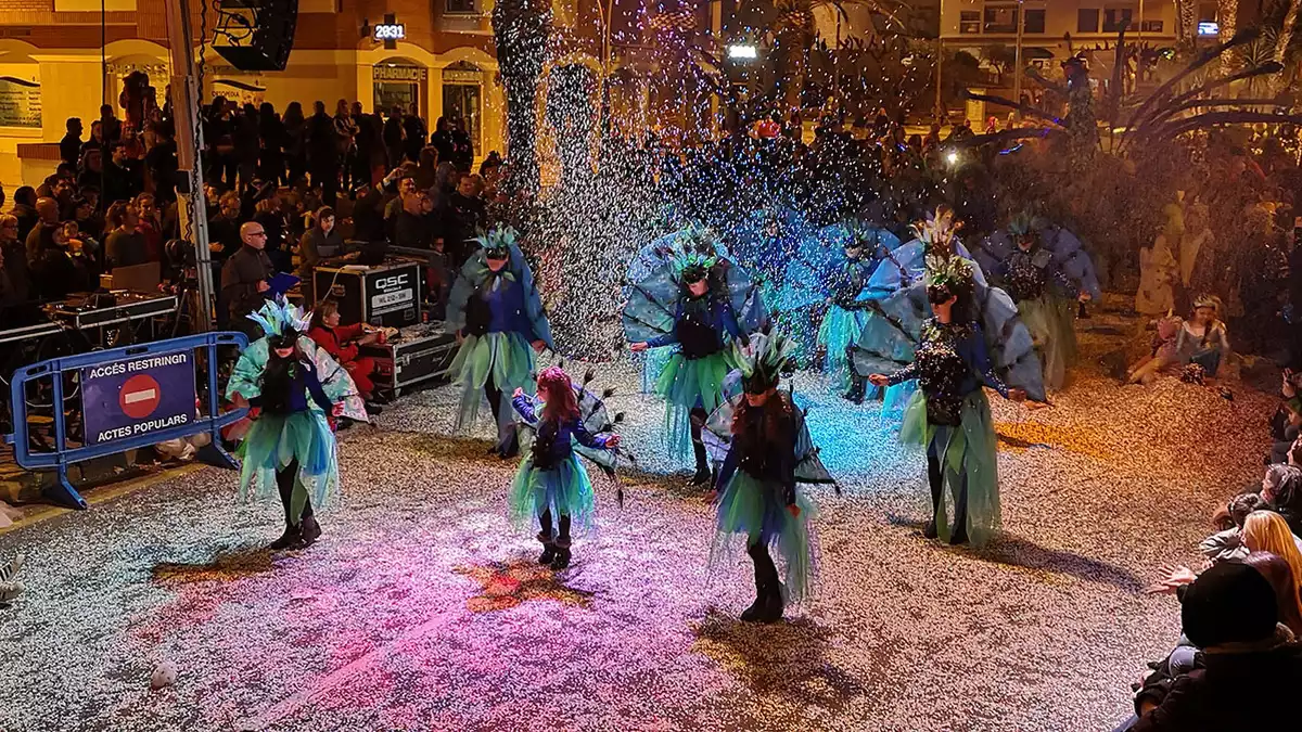 Una comparsa del Carnaval de l'Hospitalet de l'Infant ballant sota el confeti.