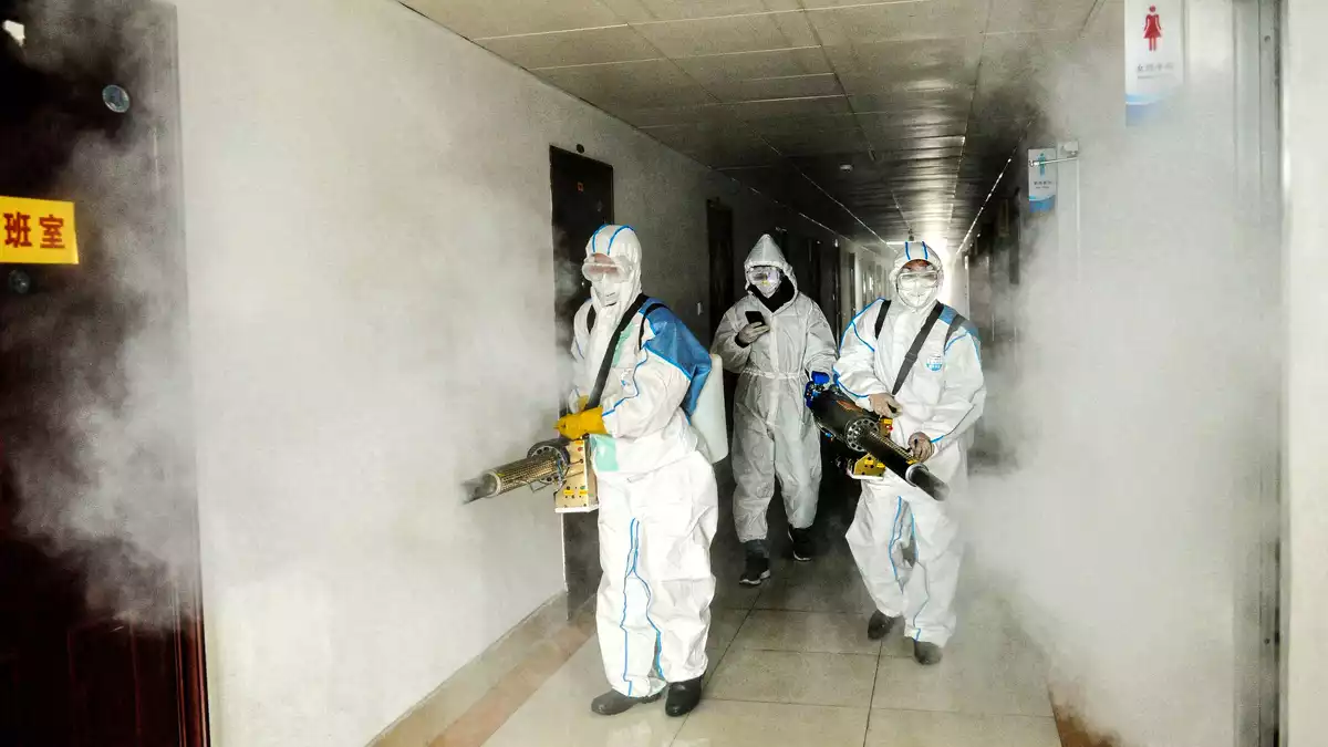 Voluntaris desinfectant una àrea administrativa a la Xina pel coronavirus el gener de 2020