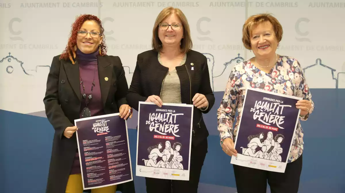 La regidora Hélène Arcelin, l'alcaldessa Camí Mendoza i la representant del Consell de Dones, Anna Morera, amb el cartell de les Jornades per la Igualtat de Gènere de Cambrils.