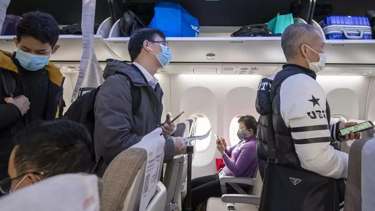 Viatgers xinesos amb mascaretes en un vol a la Xina el 8 de febrer de 2020