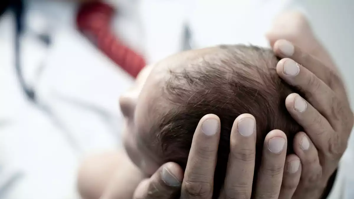 Doctor aguantant cap d'un nadó