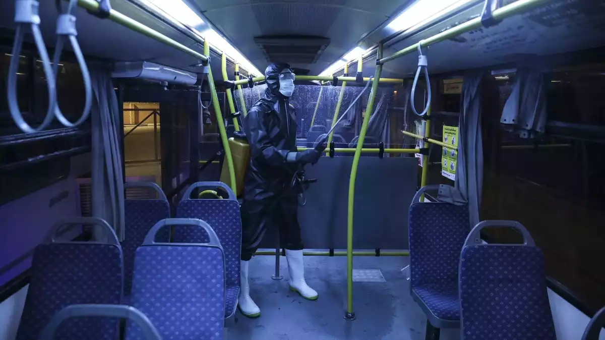 Una persona netejant l'interior d'un autobús a Iran per combatre el coronavirus