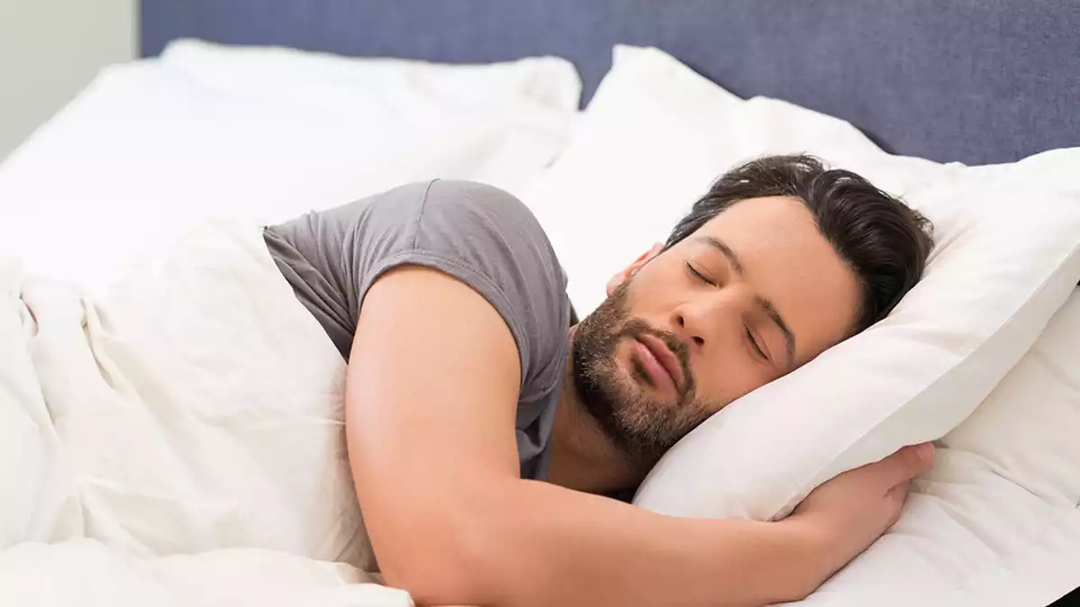 Un home dormint dins d'un llit