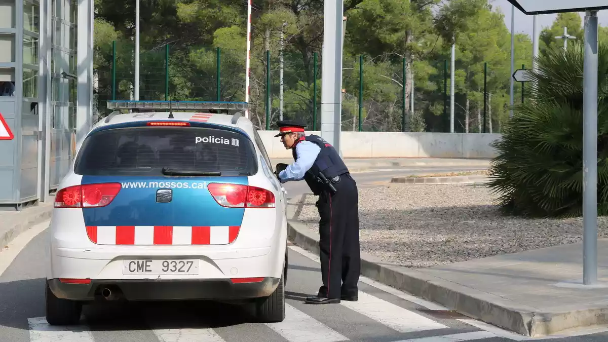 Un agent dels Mossos d'Esquadra al costat del seu vehicle