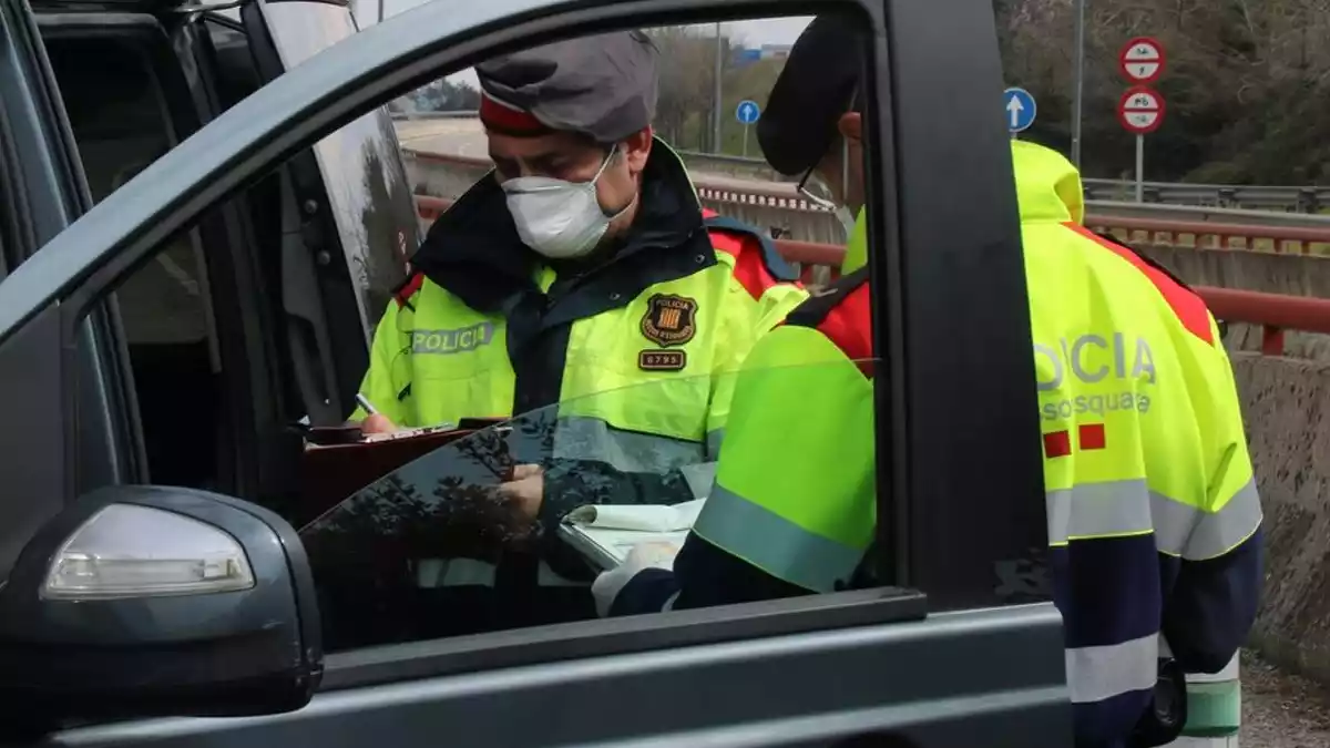 Instant en què els Mossos imposen la sanció als ocupants de la furgoneta aquest dissabte 21 de març de 2020 a Maçanet de la Selva.