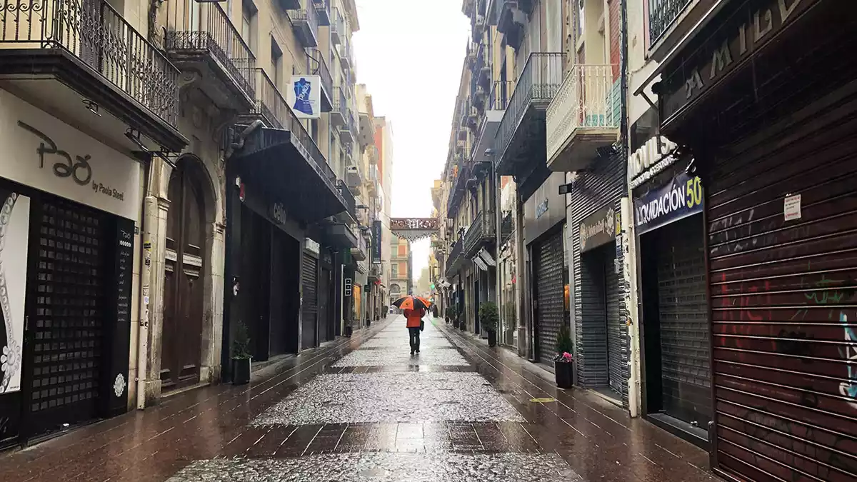 Una persona caminant pel carrer Monterols de Reus.