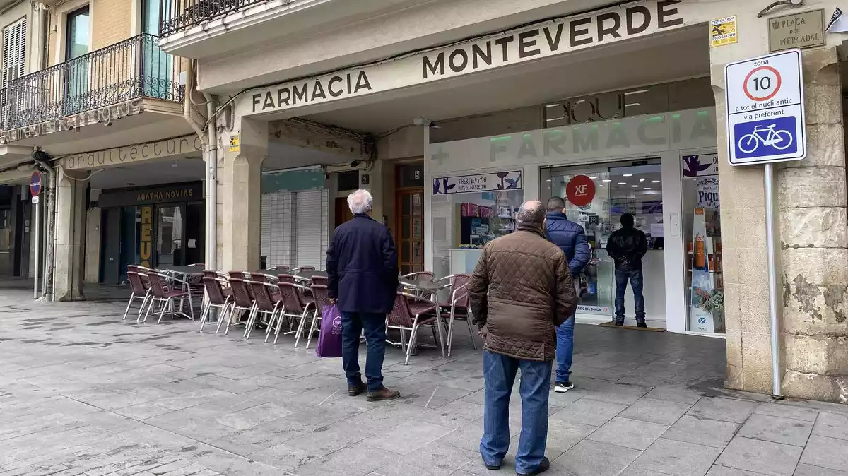 Imatge de persones fent cua a la farmàcia de la plaça del Mercadal de Reus