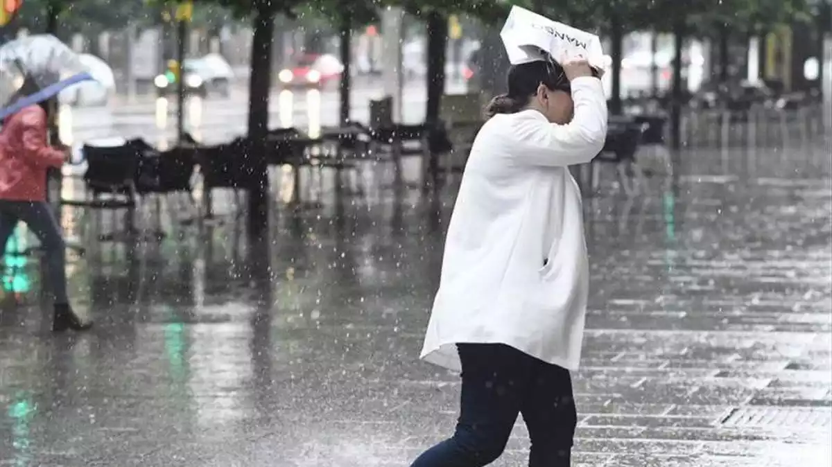 Imatge d'una dona tapant-se de la pluja