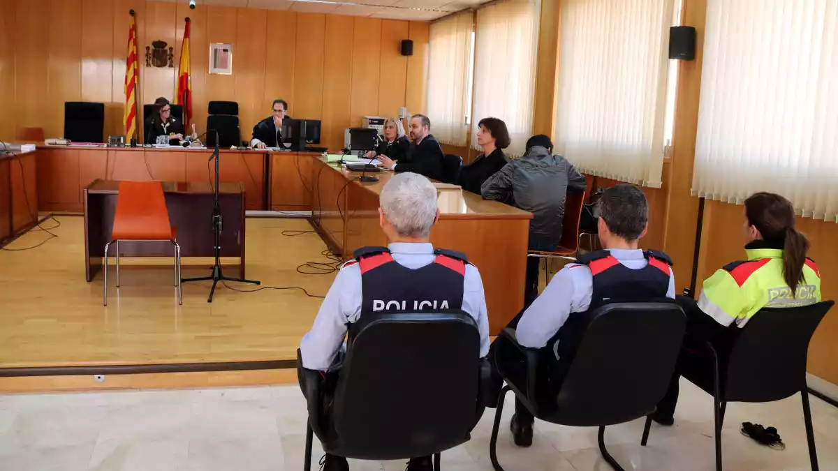 La sala de vistes de l'Audiència de Tarragona, amb tres agents dels Mossos en primer terme, amb l'acusat assegut, d'esquenes, a la dreta