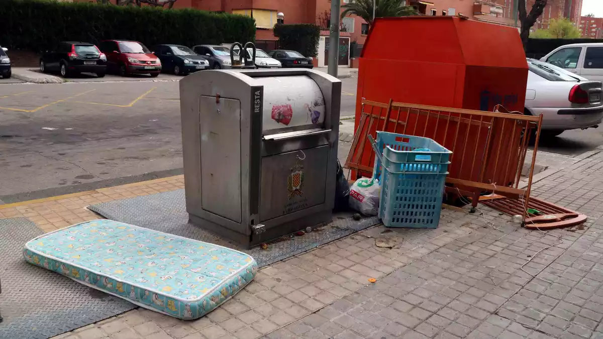 Pla obert d'un contenidor soterrat de Tarragona amb diversos voluminosos a la vora