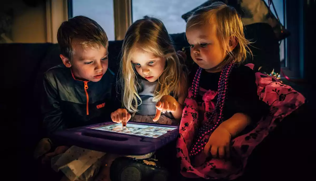 Imatge de tres infants jugant a la tablet