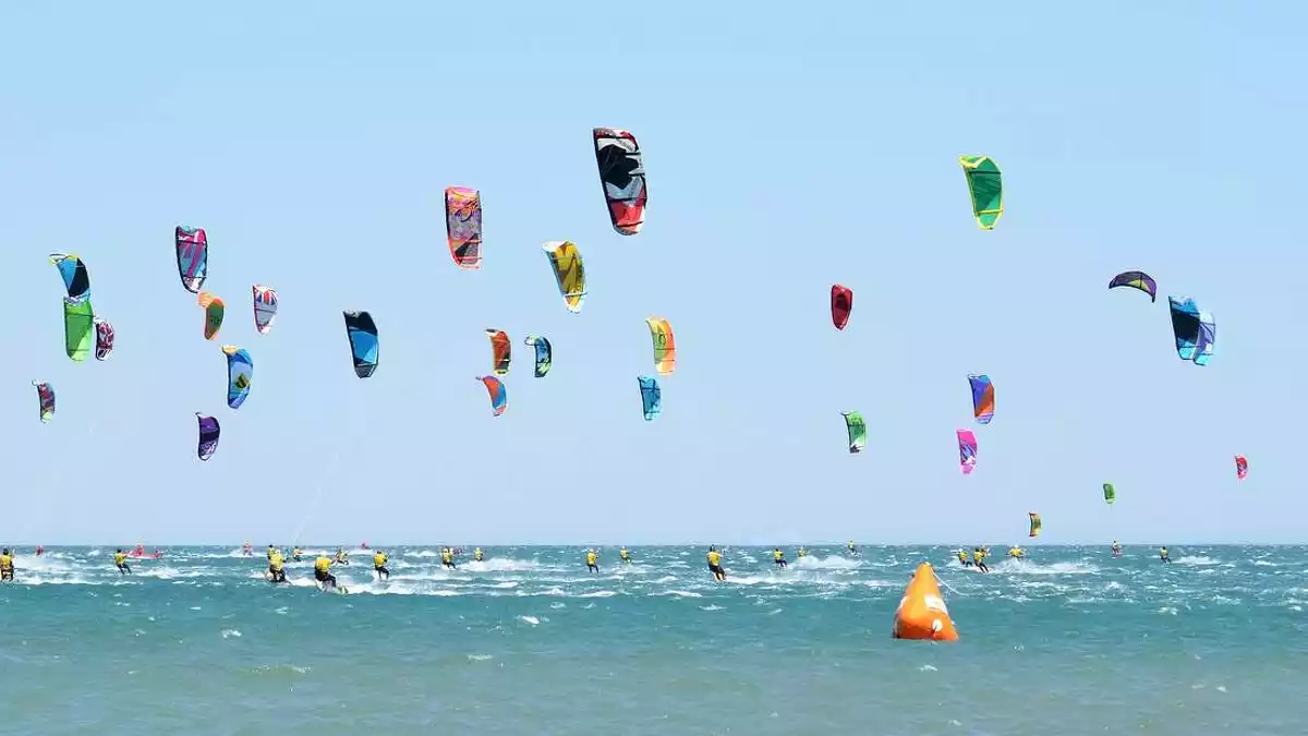 Gent practicant kitesurf a la platja