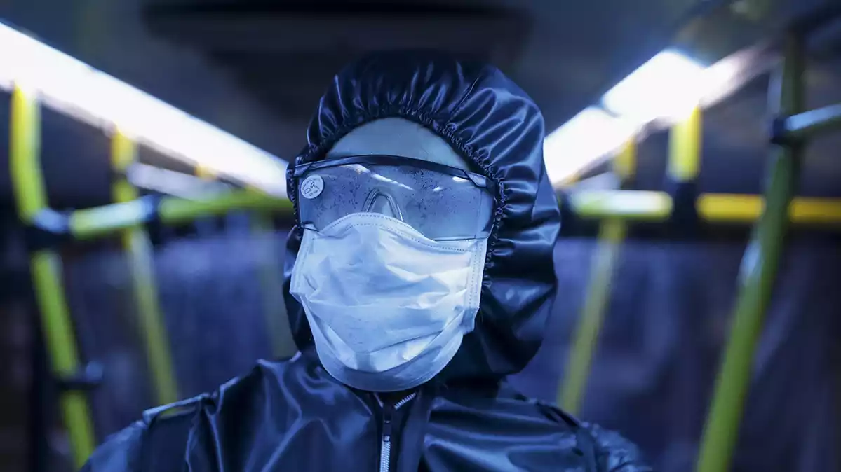 Una persona desinfectant un autobus pel coronavirus