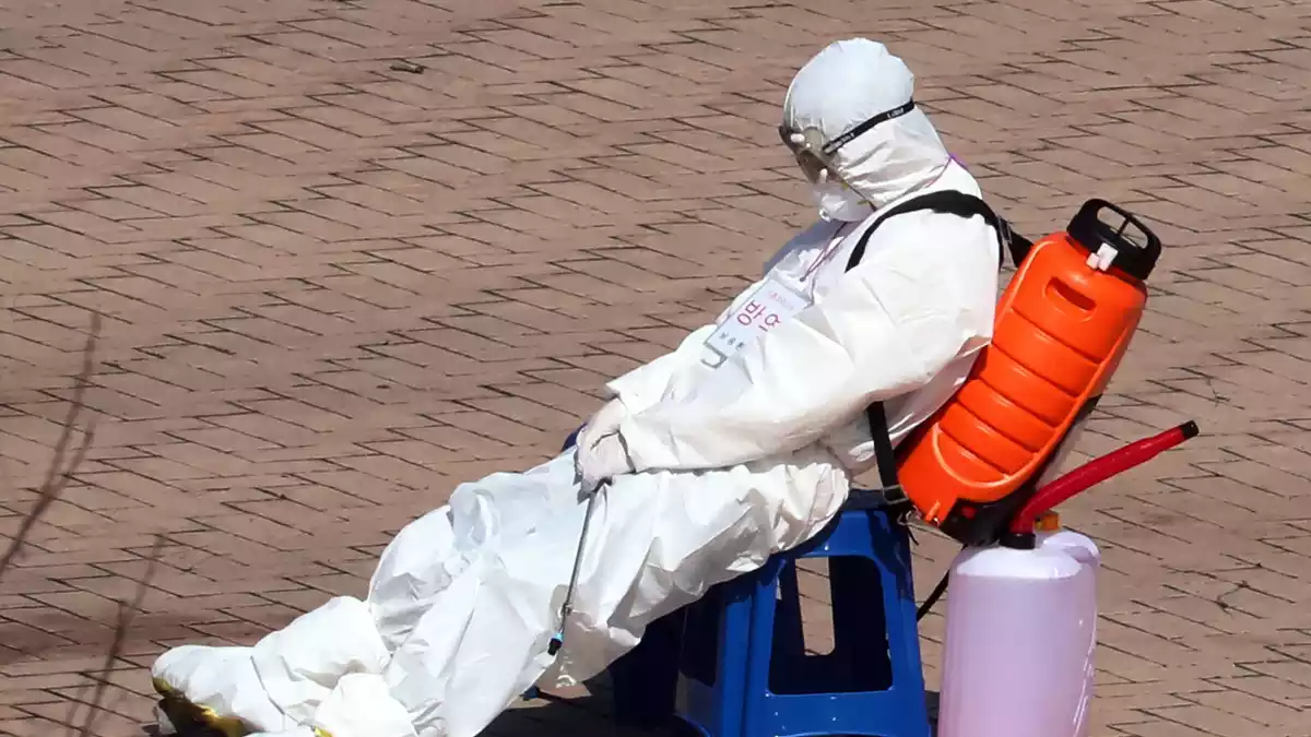 Un home amb roba de protecció descansant de desinfectar els carrers a Corea del Sud el 6 de març de 2020