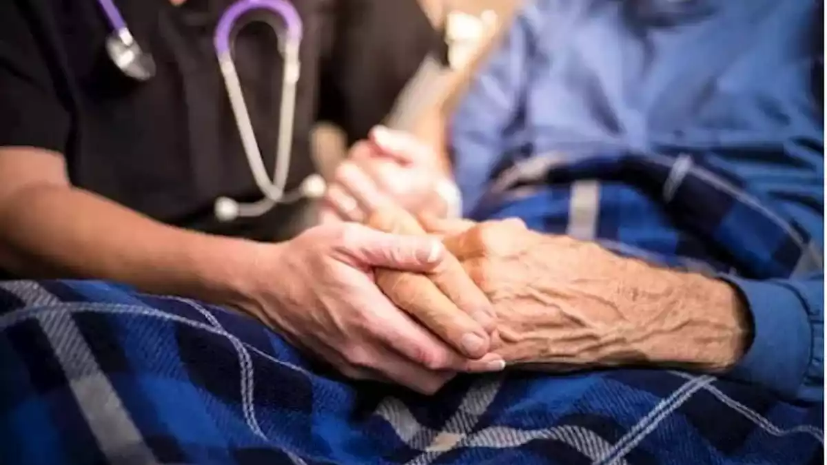 Enfermera de ciudados paliativos con una señora mayor