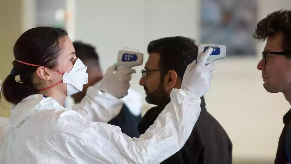 Equip mèdic revisant la temperatura corporal dels passatgers que arriben a l'aeroport de Bratislava