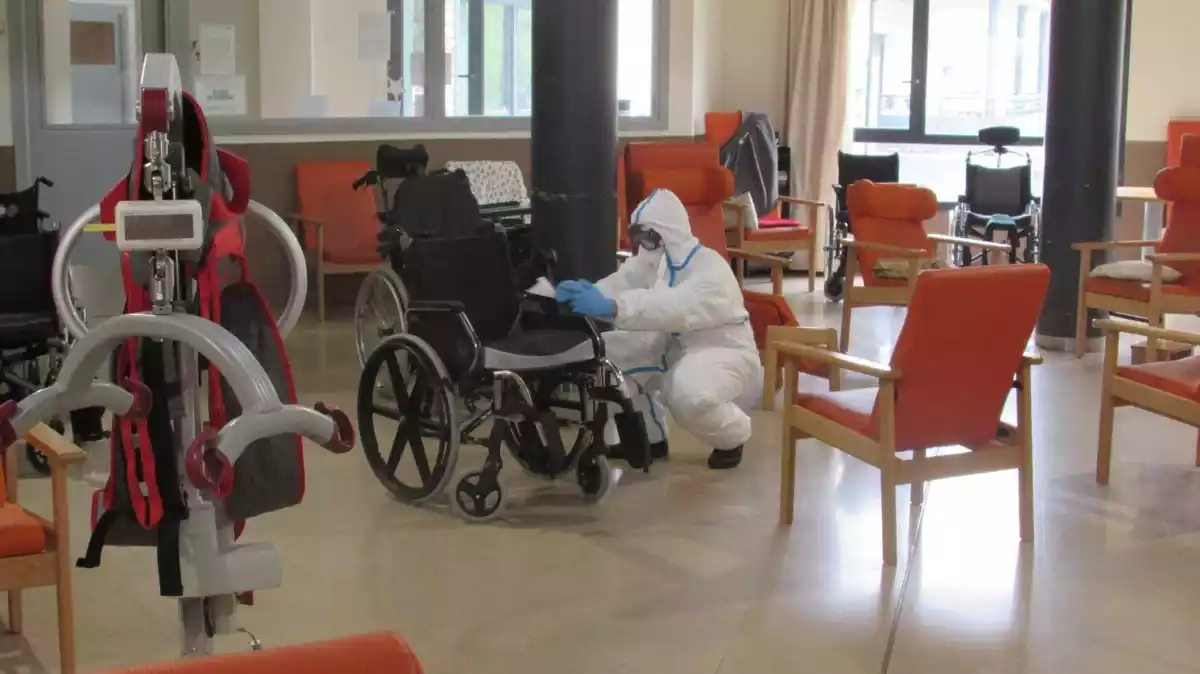 Un efectiu del Grup Sanitari de l'Exèrcit duent a terme treballs de desinfecció d'una residència de gent gran