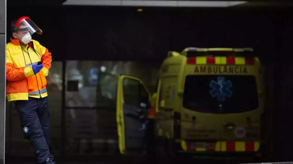 Sanitari esperant a l'entrada de l'Hospital Sant Pau de Barcelona al costat d'una ambulància , 5 d'abril de 2020