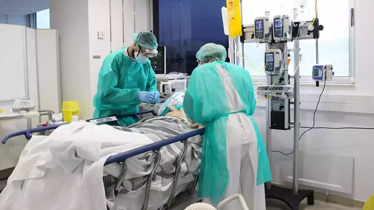 Pla mitjà de dos metges tenint cura d'un pacient amb coronavirus aquest dissabte 18 d'aril de 2020 a l'hospital Trueta