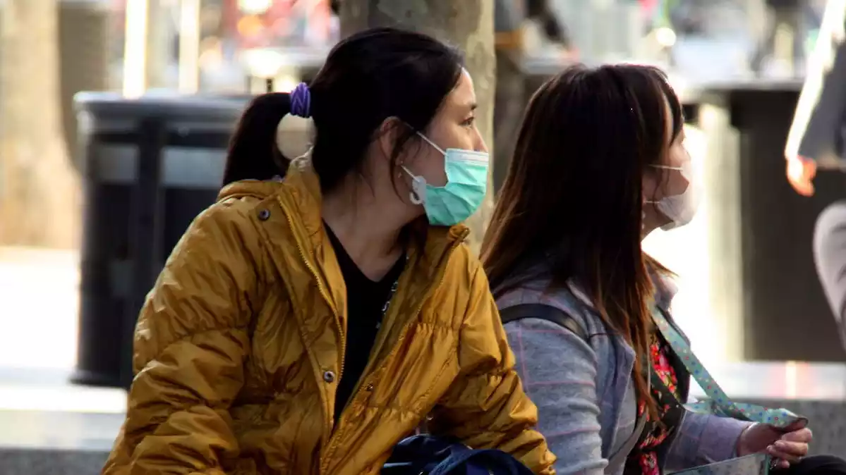 Pla general de dues noies que duen mascareta com a mesura preventiva pel coronavirus