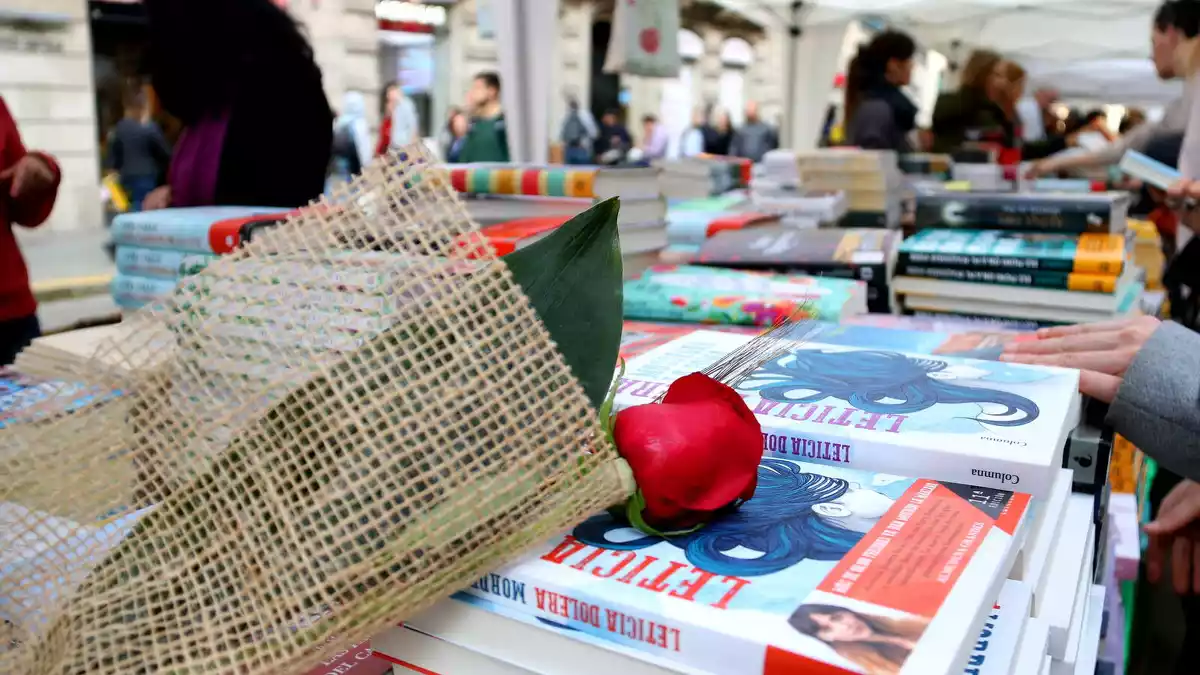 Llibres i una rosa en una paradeta durant el Sant Jordi 2019 a Barcelona