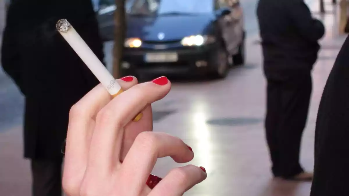 Una mà sosté una cigarreta