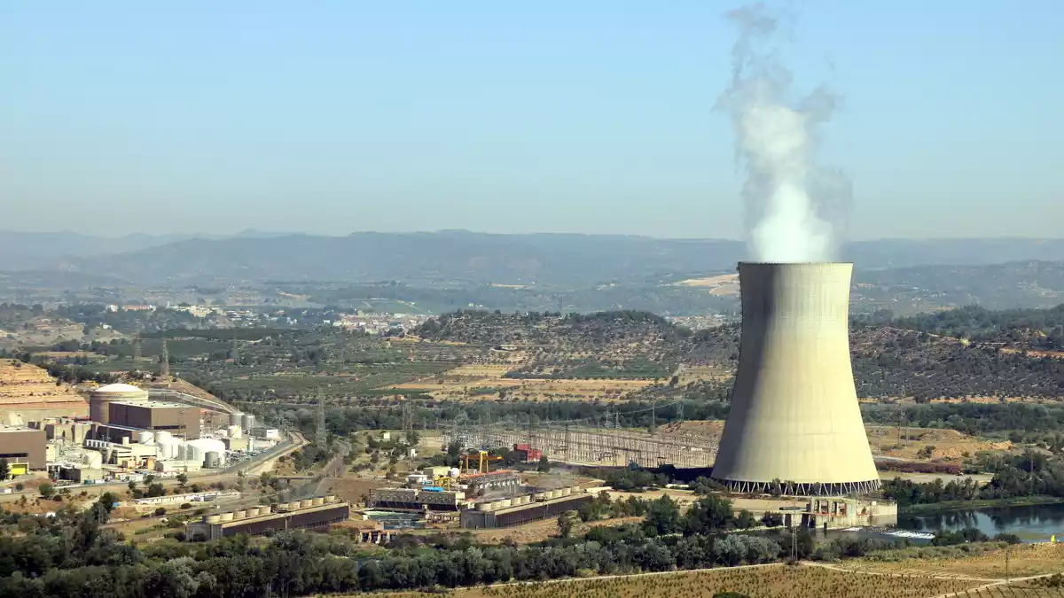 Imatge de la central nuclear d'Ascó, a la Ribera d'Ebre, amb la xemeneia fumejant a la dreta i els dos reactors a l'esquerra