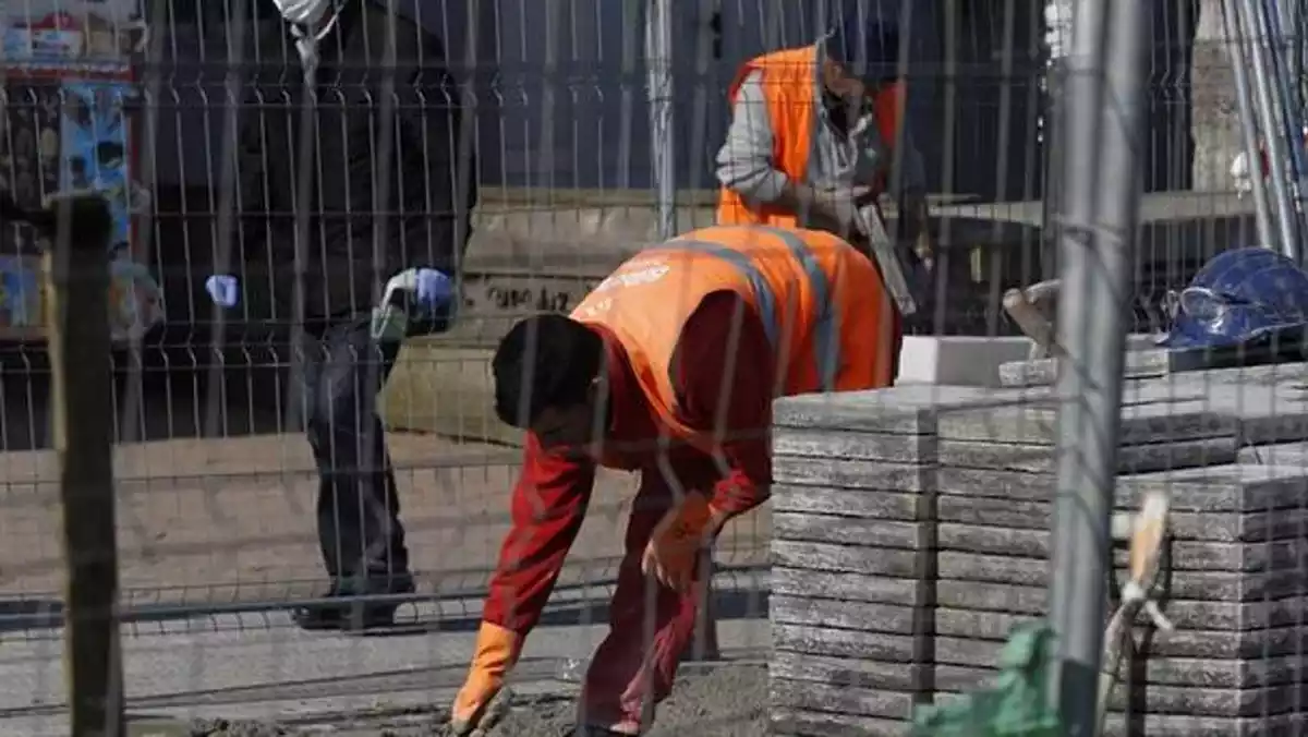 Un obrero trabajando en una obra de construcción con el equipamiento profesional