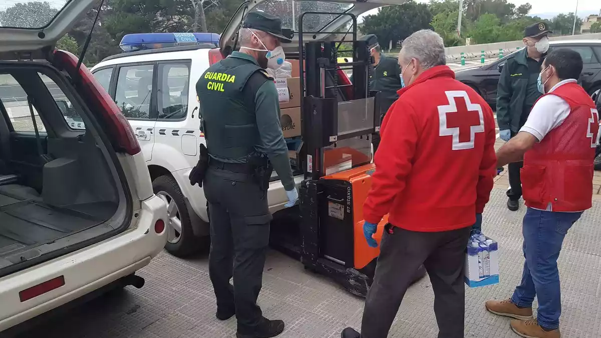 Imatge de la Guàrdia Civil carregant aliments i material sanitari per ajudar la Creu Roja