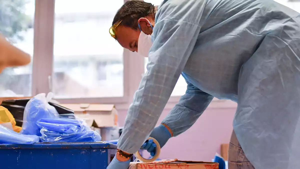 Un home embala una capsa de material de prevenció