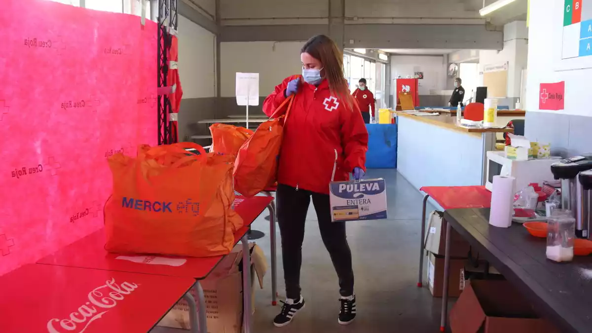 La tècnica de Creu Roja Tarragona, Marta Flores, descarrega el menjar que donen als sensesostre que han trobat feina perquè puguin subsistir fins que cobrin el primer sou
