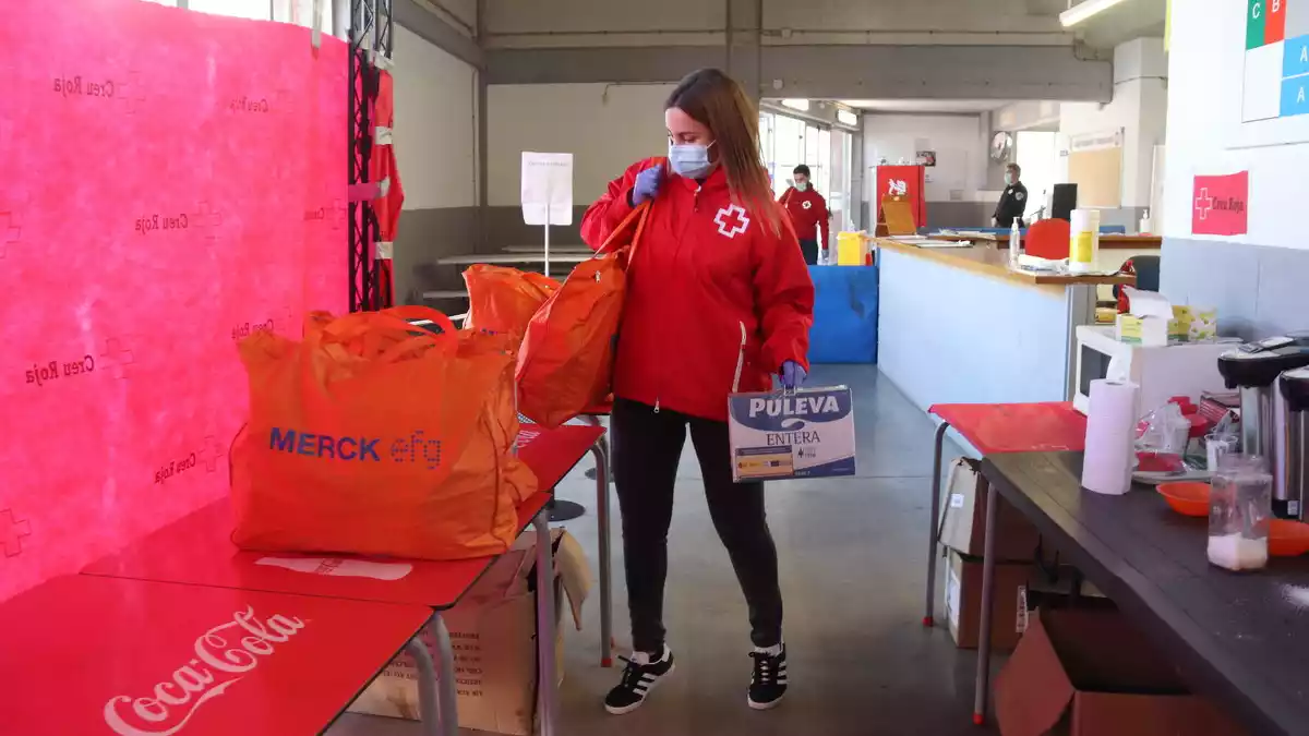 La tècnica de Creu Roja Tarragona, Marta Flores, descarrega el menjar que donen als sensesostre que han trobat feina perquè puguin subsistir fins que cobrin el primer sou