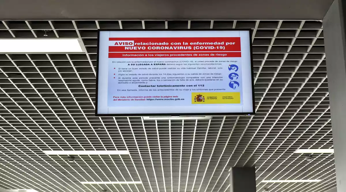 Pantalla d'aeorport anunciant les mesures previstes pel coronavirus.