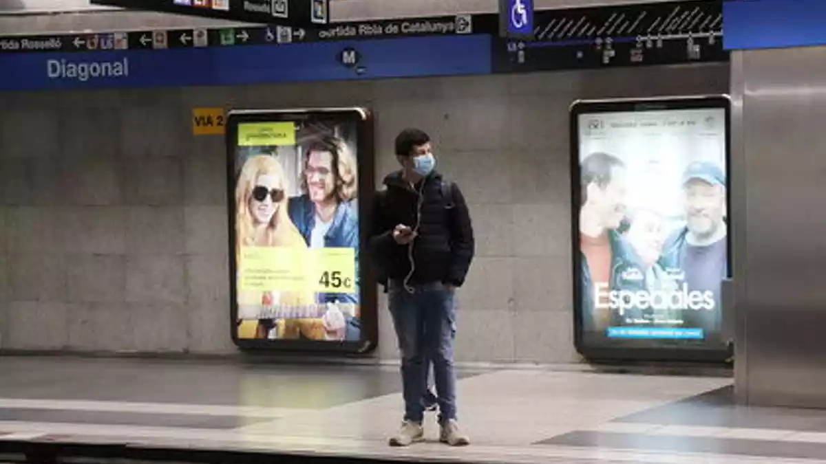 Una persona amb mascareta esperant el Metro a Barcelona el 13 d'abril de 2020
