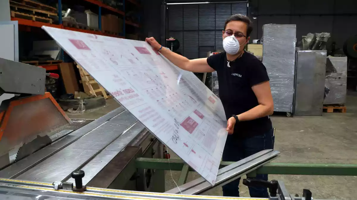 Núria Piqué, propietària de l'empresa Proycsa de Valls, transportant una peça de policarbonat a la nau de l'empresa al polígon industrial de Valls