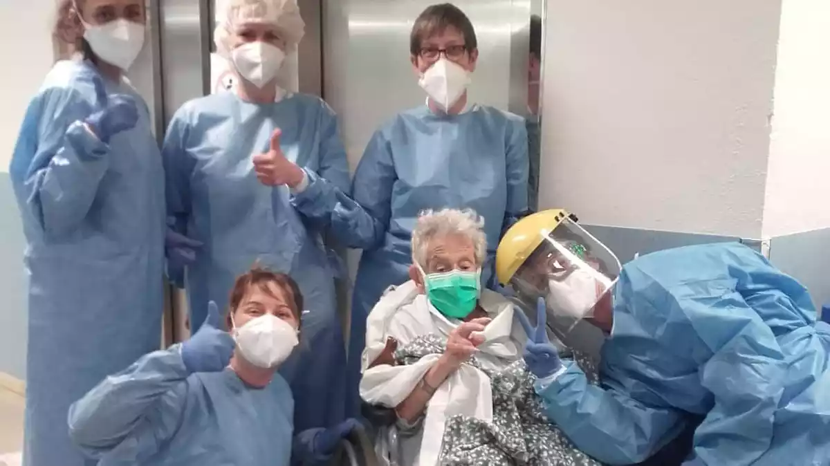 Els professionals sanitaris del Pius Hospital de Valls acompanyant una pacient donada d'alta després de patir coronavirus