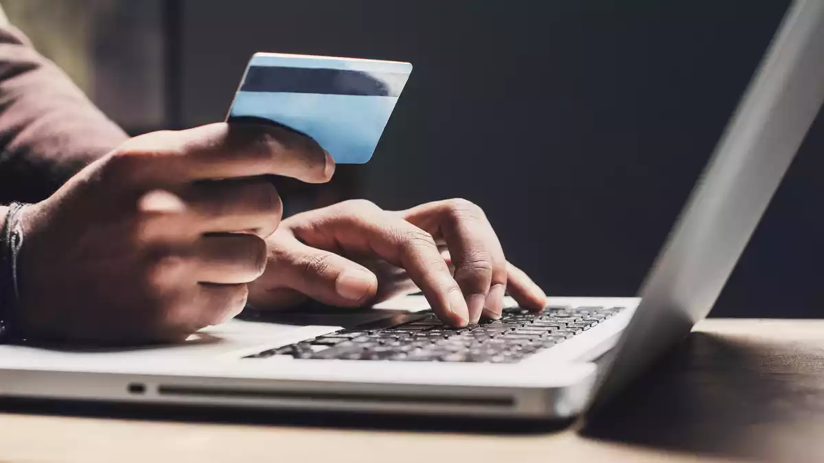 Imagen de una persona utilizado la targeta de crédito para una compra por internet
