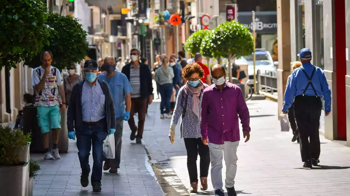 Pla general de diverses persones amb mascareta caminant pel centre de Reus