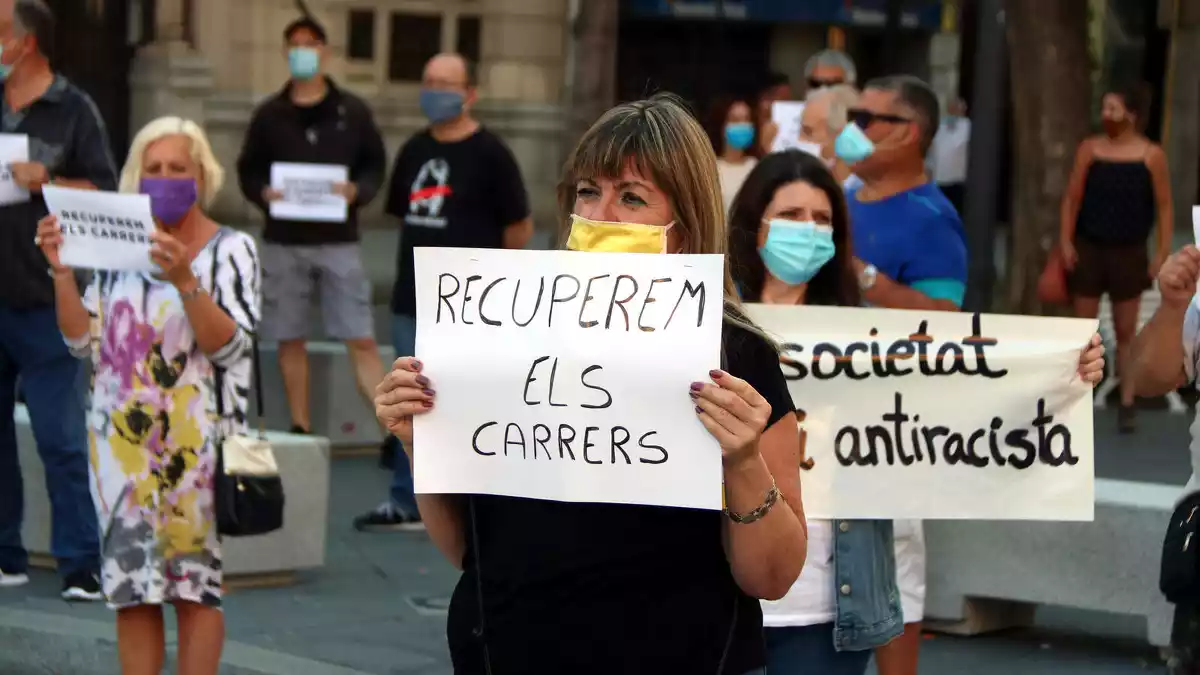 Pla mitjà d'una dona a la concentració de la Rambla Nova de Tarragona que mostra un cartell amb el lema 'Recuperem els carrers'